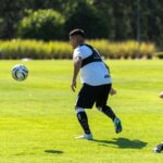 Players in action during a soccer training session outdoors on a sunny day.
