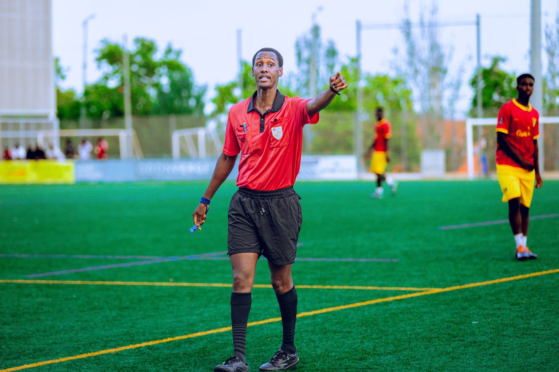 Referee in action during a football match, outdoors on a green field.