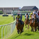 Jockeys compete intensely at the Musselburgh Racecourse in Scotland, showcasing equestrian skill and speed.