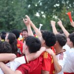 Excited fans celebrate at an outdoor sports event in Madrid, expressing joy and unity.