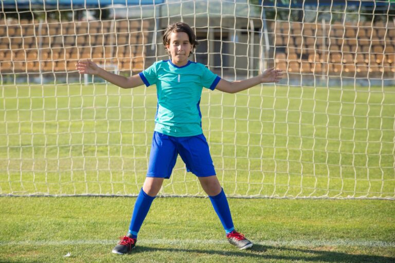 A young soccer goalkeeper in action on the field in Portugal, showcasing athletic skills and determination.