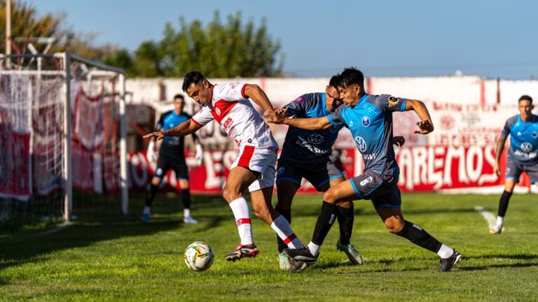 Football players engage in a competitive match, showcasing skill and teamwork on a grassy field.