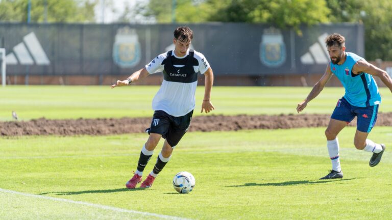Two soccer players in action on a sunny day during an outdoor match.