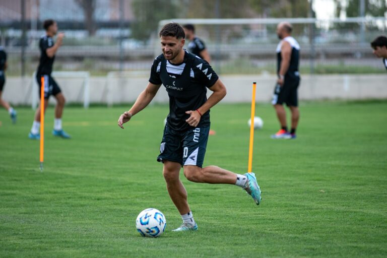 Athlete practicing soccer drills outdoors with teammates on a sunny day.