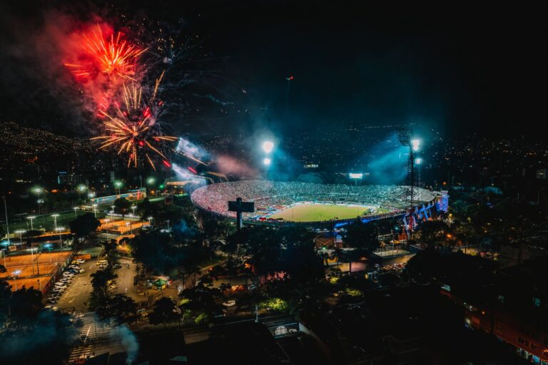 A vibrant display of fireworks over a packed stadium in Medellín, Colombia, creating a festive atmosphere.