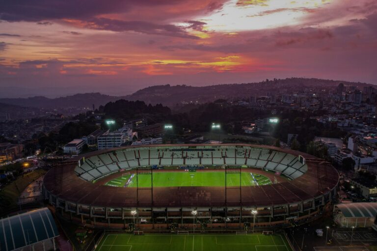 Captivating aerial view of a soccer stadium in Manizales, Colombia, under a vibrant sunset sky.
