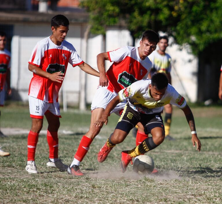 Players in dynamic action during a competitive outdoor football match on a sunny day.