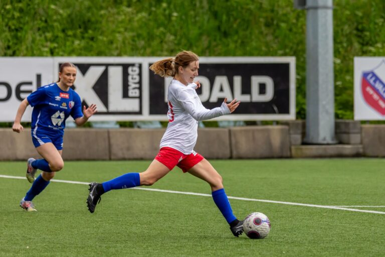 Dynamic action shot of a women's soccer game in Norway, showcasing player agility and intensity.