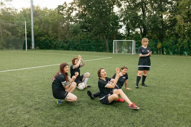 A women's soccer team celebrating joyfully on the field. Team spirit and sportsmanship.