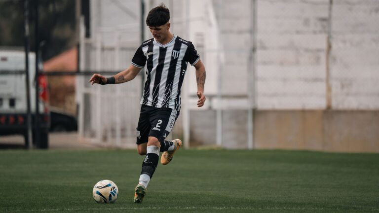 A young soccer player in action, dribbling the ball during a game on the field.