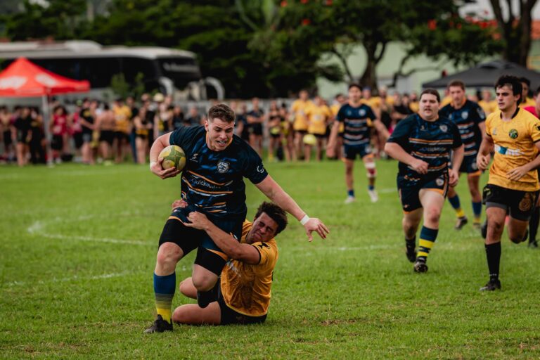 Rugby players competing intensely on a green outdoor field, showcasing athleticism and teamwork.