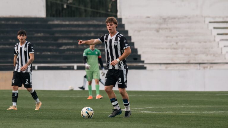 Young soccer players in action during a competitive match at an outdoor stadium.