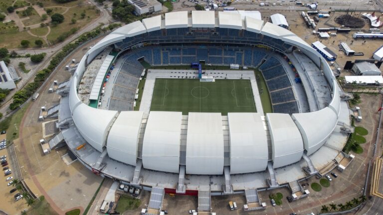 Aerial view of the Arena das Dunas stadium in Natal, Brazil, showcasing its modern architecture and empty seating areas.