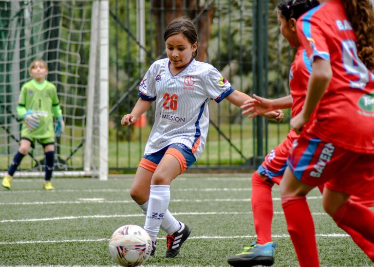 Young soccer players in action during a competitive match outdoors.