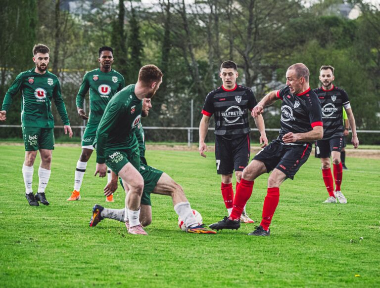 Dynamic football scene with players in action on a green pitch in France.