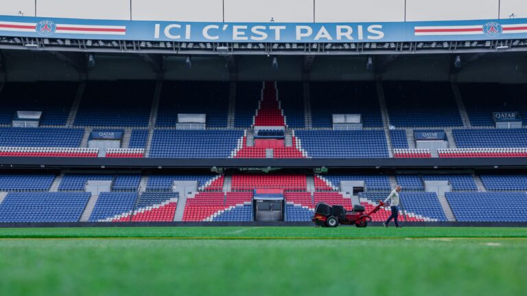 Gardener working on the field at Parc des Princes stadium, Paris. Vibrant and iconic sports venue.