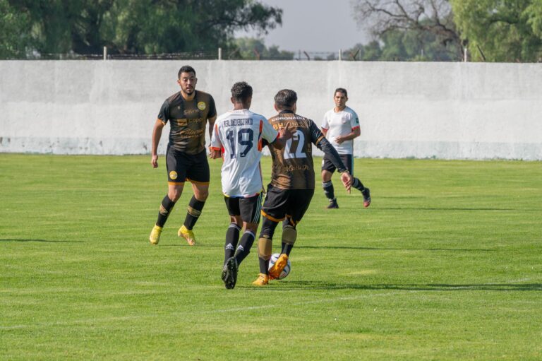 Soccer players in action on a sunny day on a grassy field.