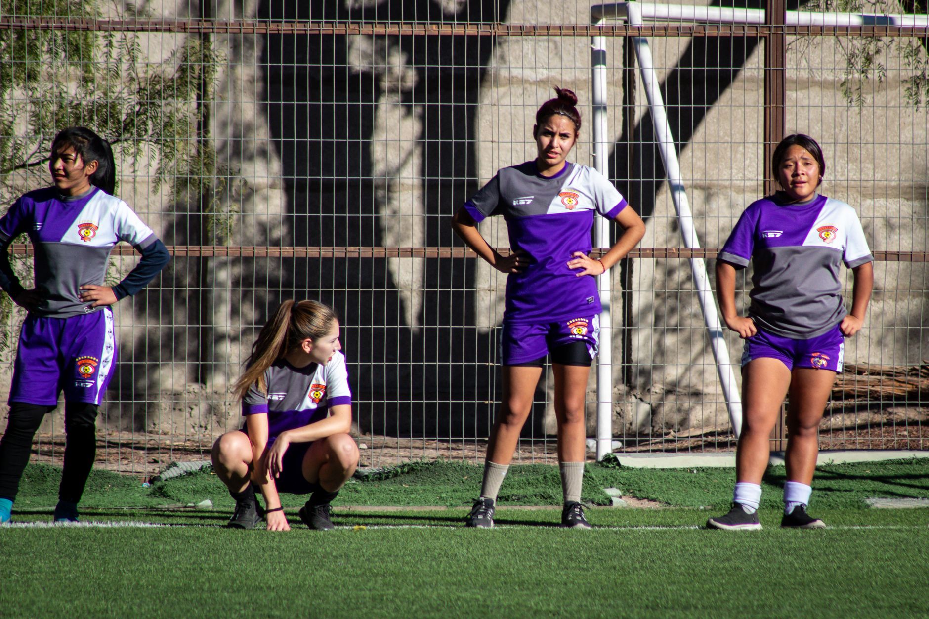 Group of female soccer players warming up on the field, preparing for a game.