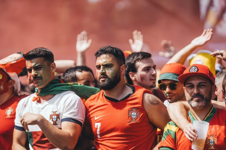 Group of passionate soccer fans cheering during a match, showcasing team spirit and celebration.