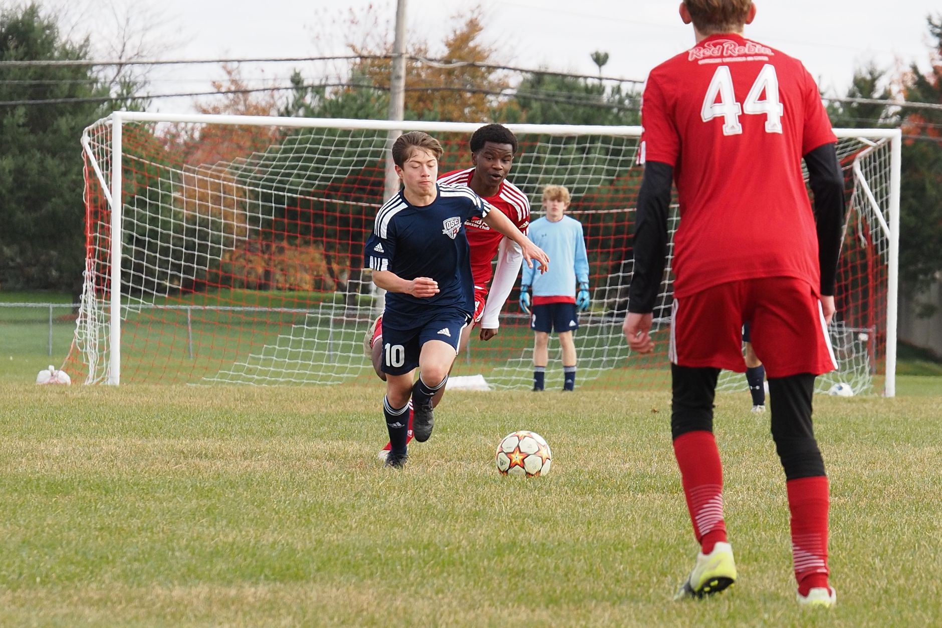 Dynamic action shot of teenage soccer game capturing intense competition and teamwork.