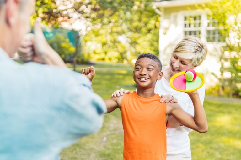 Cheerful family enjoying a velcro ball game outdoors, capturing happiness and bonding.