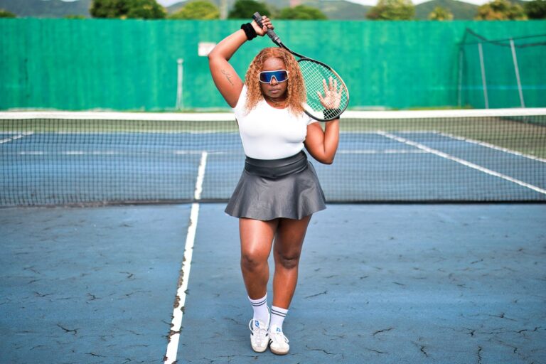 Female tennis player poses confidently with a racket on an outdoor court in Saint Kitts.