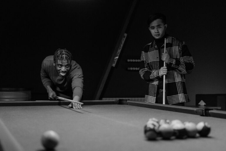 Two men focus intently as they play pool, enjoying a competitive game indoors.