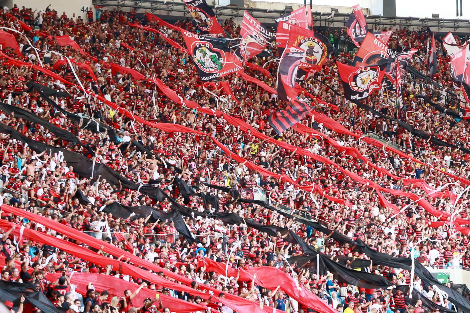 A lively crowd of football fans waving flags and banners at Maracanã Stadium, Rio de Janeiro.