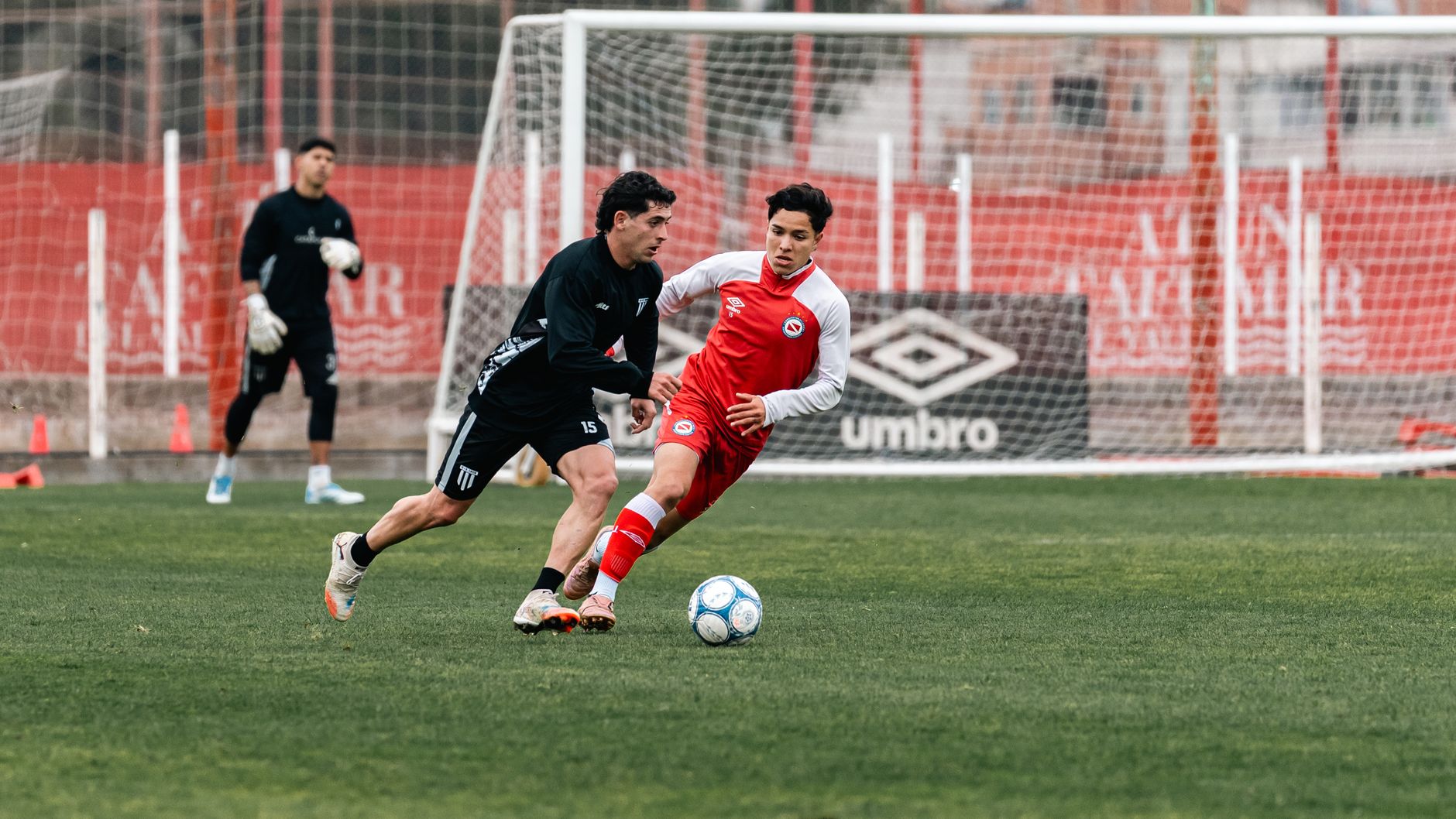Two male soccer players in action during a match, showcasing agility and competition.