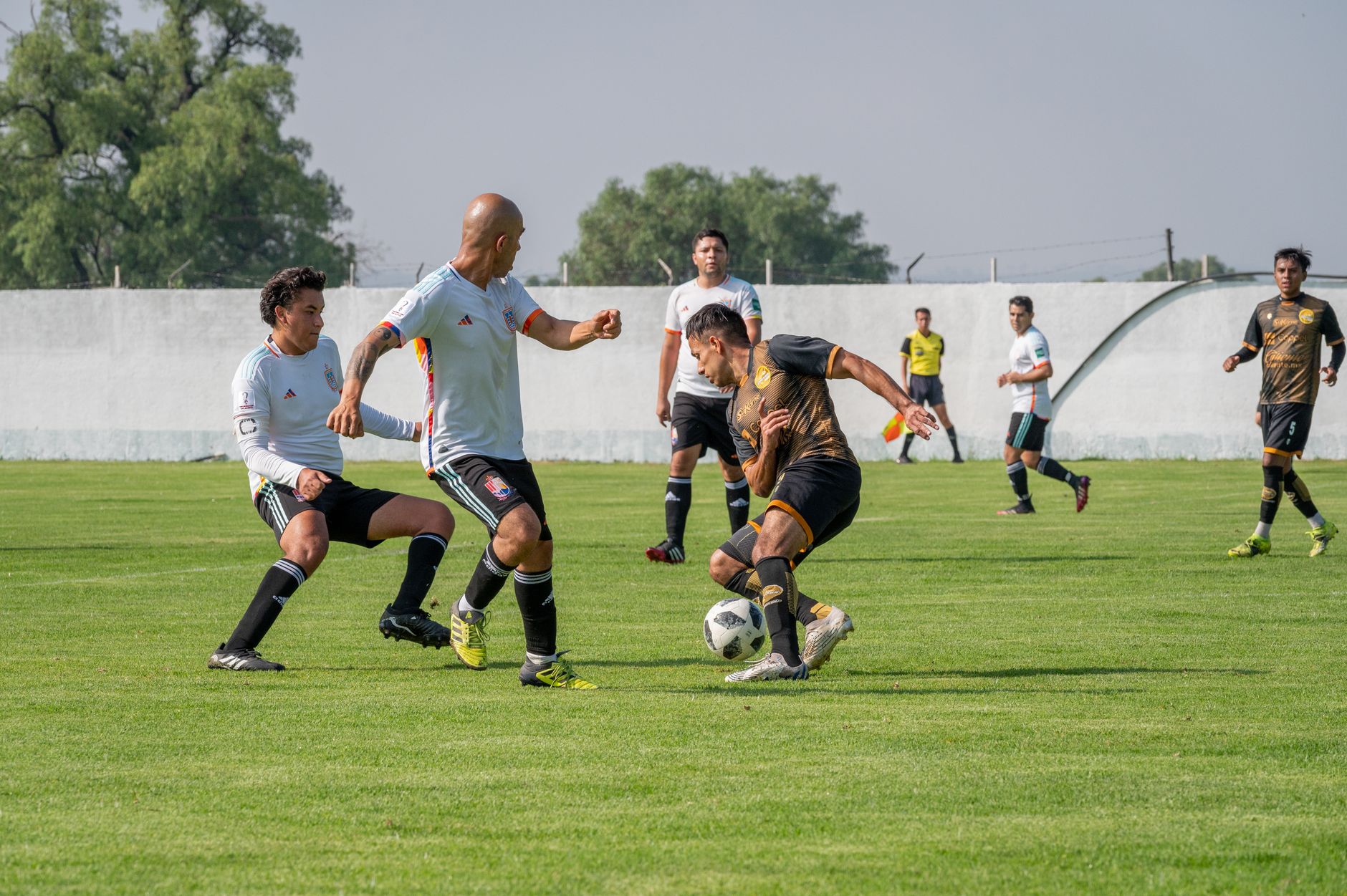 Dynamic soccer match featuring players in motion on a sunny outdoor field.
