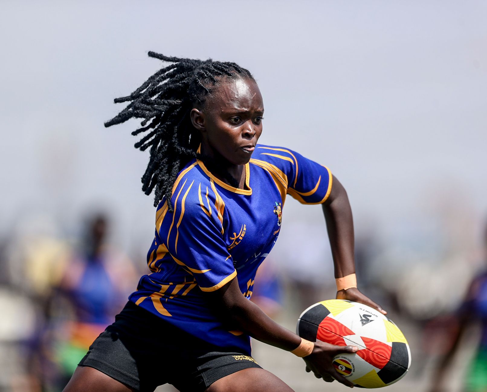 Energetic female rugby player in action during a match in Kampala, Uganda.