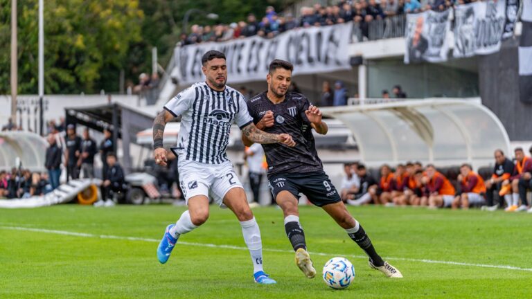 Two soccer players in action during a competitive match outdoors.