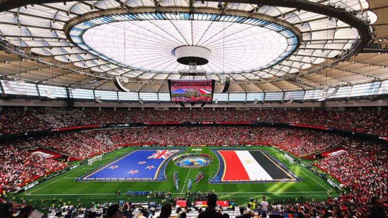 Wide-angle view of a soccer match with international flags at BC Place, Vancouver.