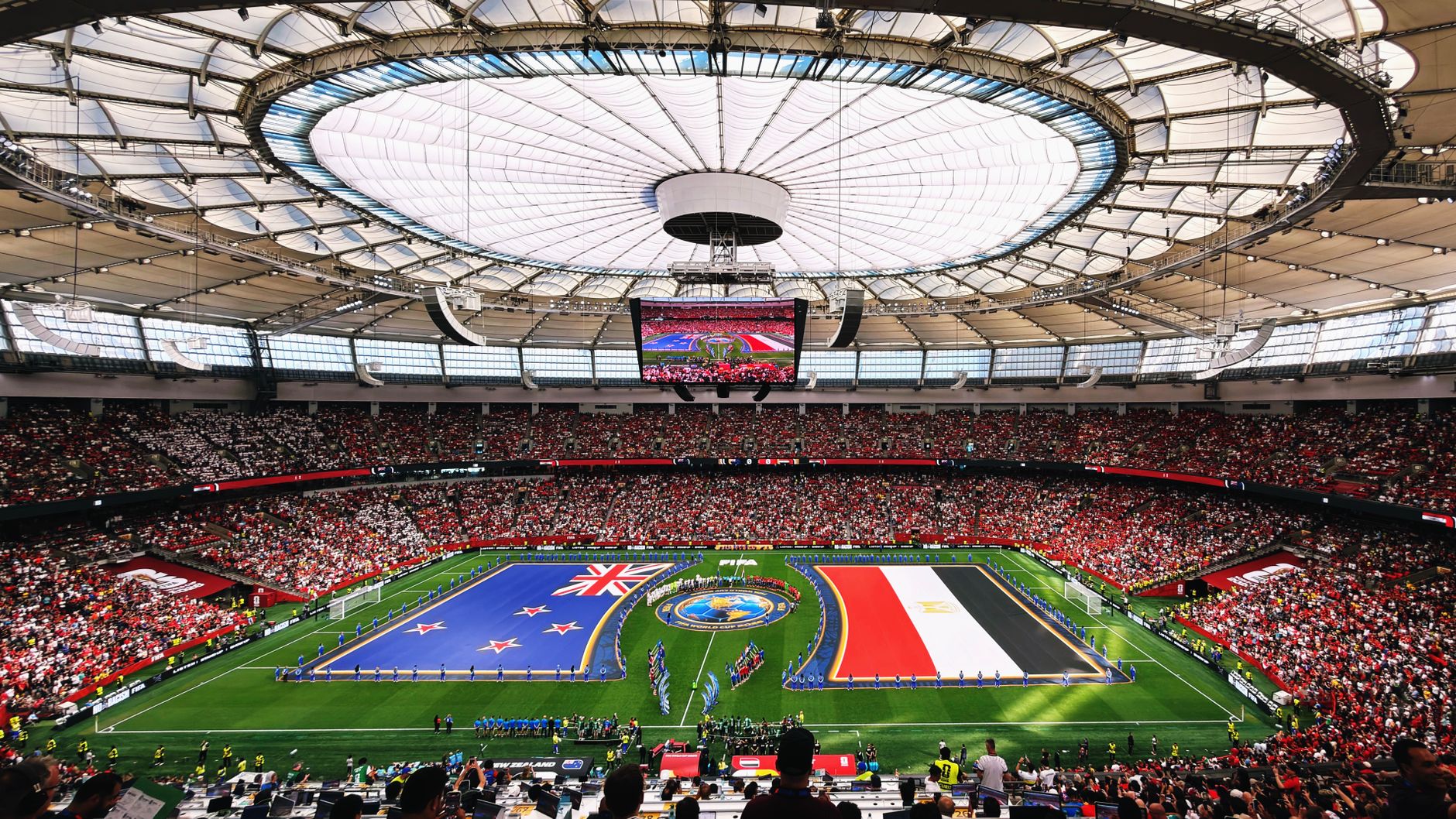 Wide-angle view of a soccer match with international flags at BC Place, Vancouver.