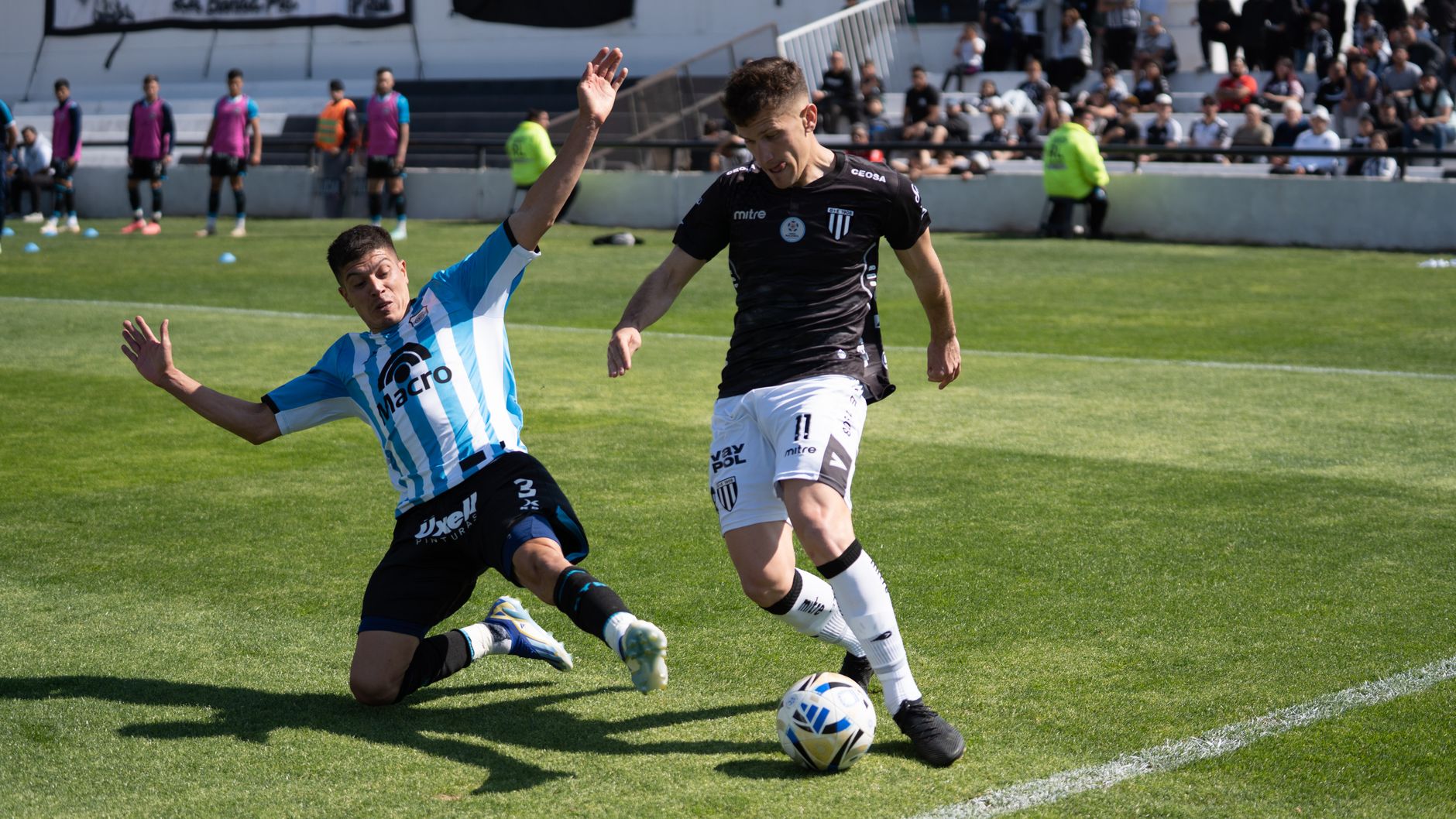 Two football players competing fiercely during a match, creating dramatic sports action.
