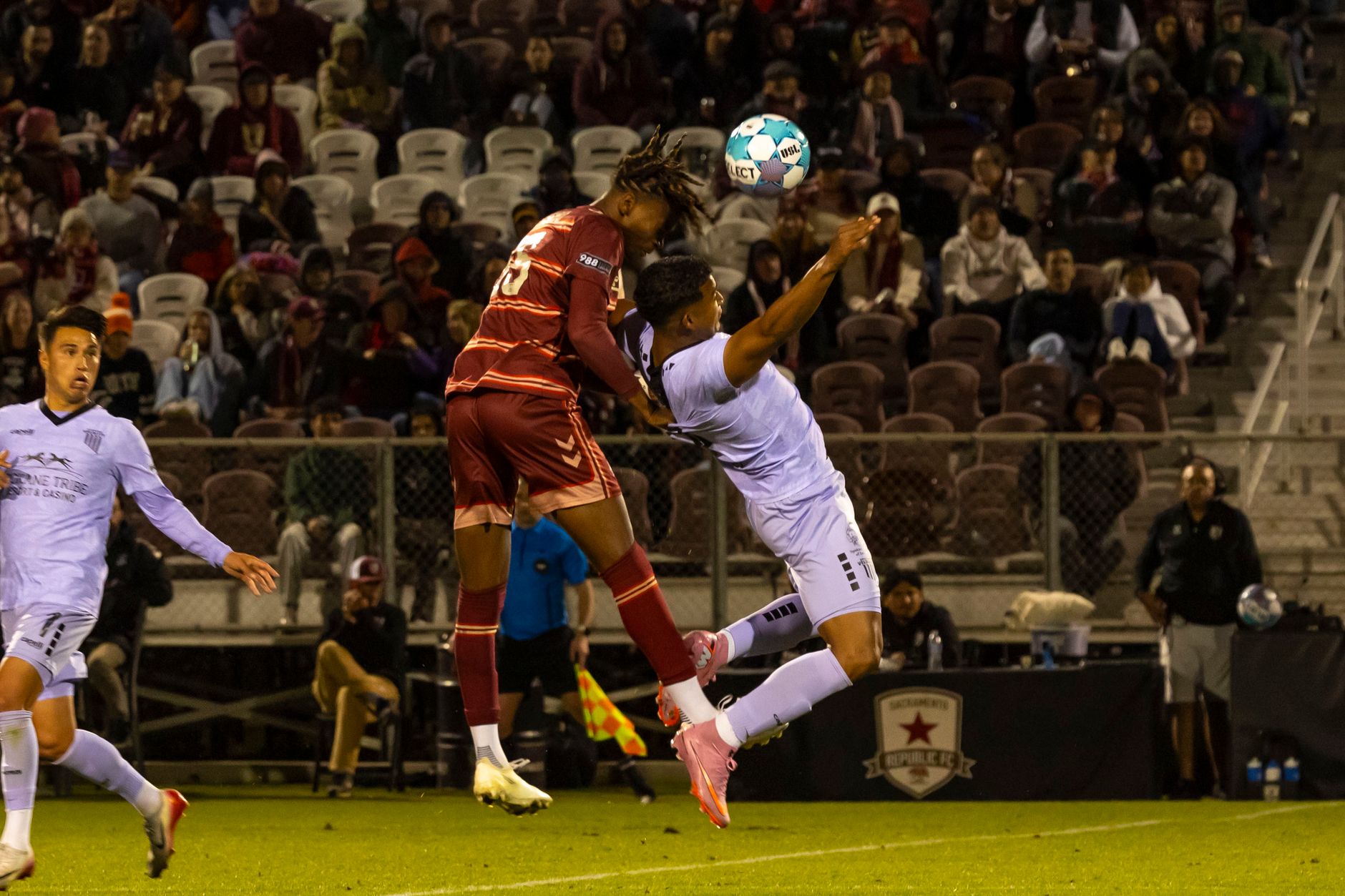 Action-packed soccer match capturing a player mid-air going for a header.