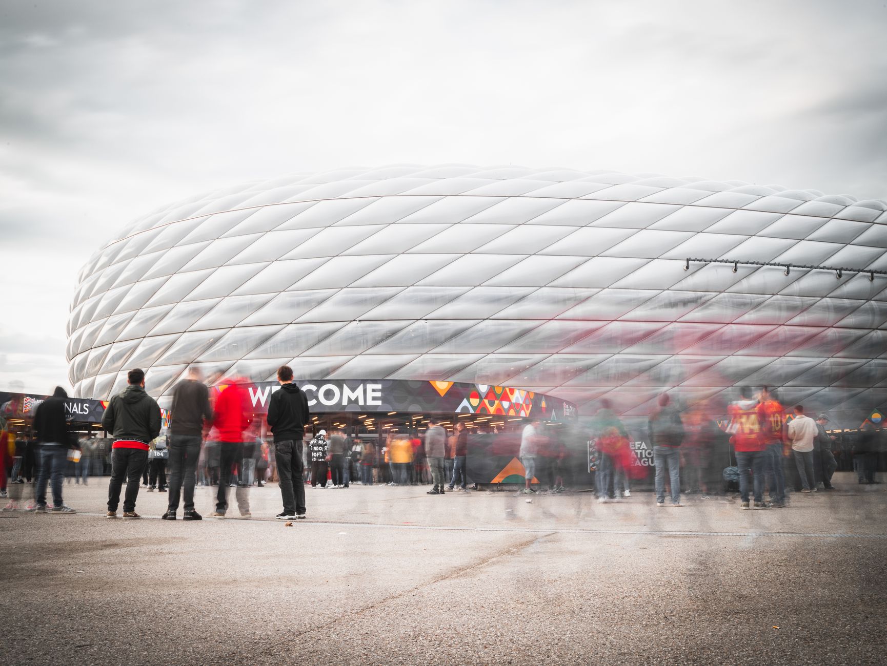 Fans gathering outside Allianz Arena in Munich, Germany, ready for a soccer event.