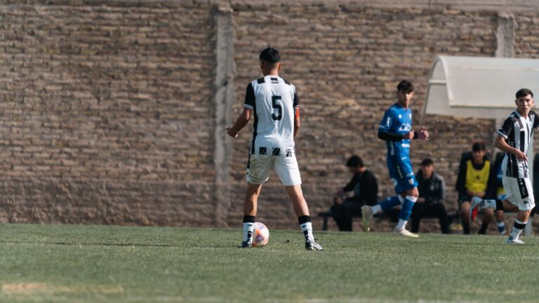 Teenage soccer player in action on the field, wearing number 5 jersey outdoors.