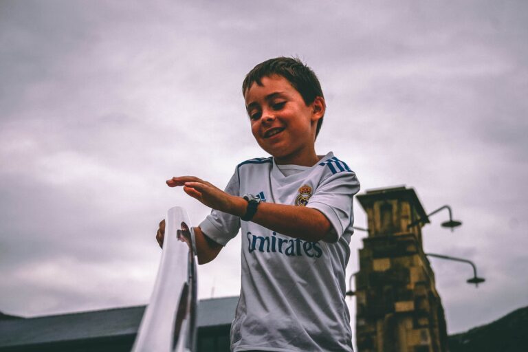 Cheerful young boy having fun outdoors on a cloudy day.