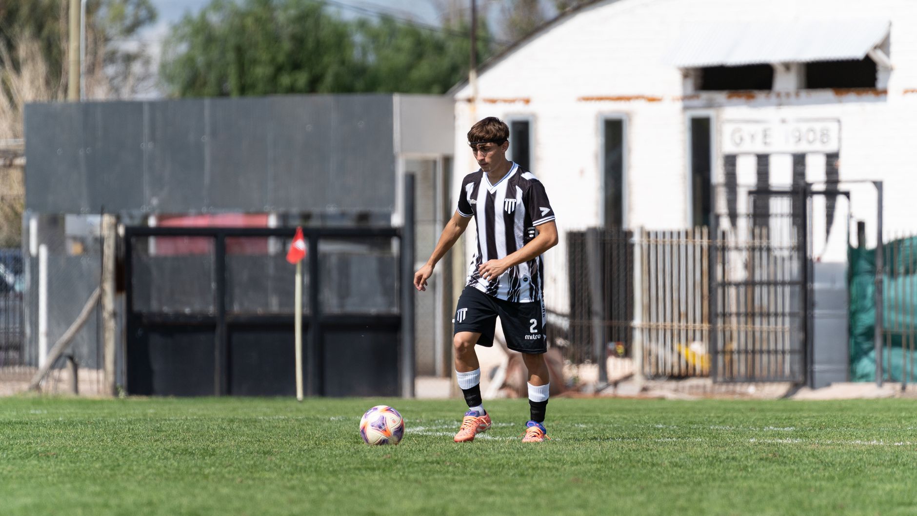 Male soccer player in black and white uniform on the field, outdoor match setting.