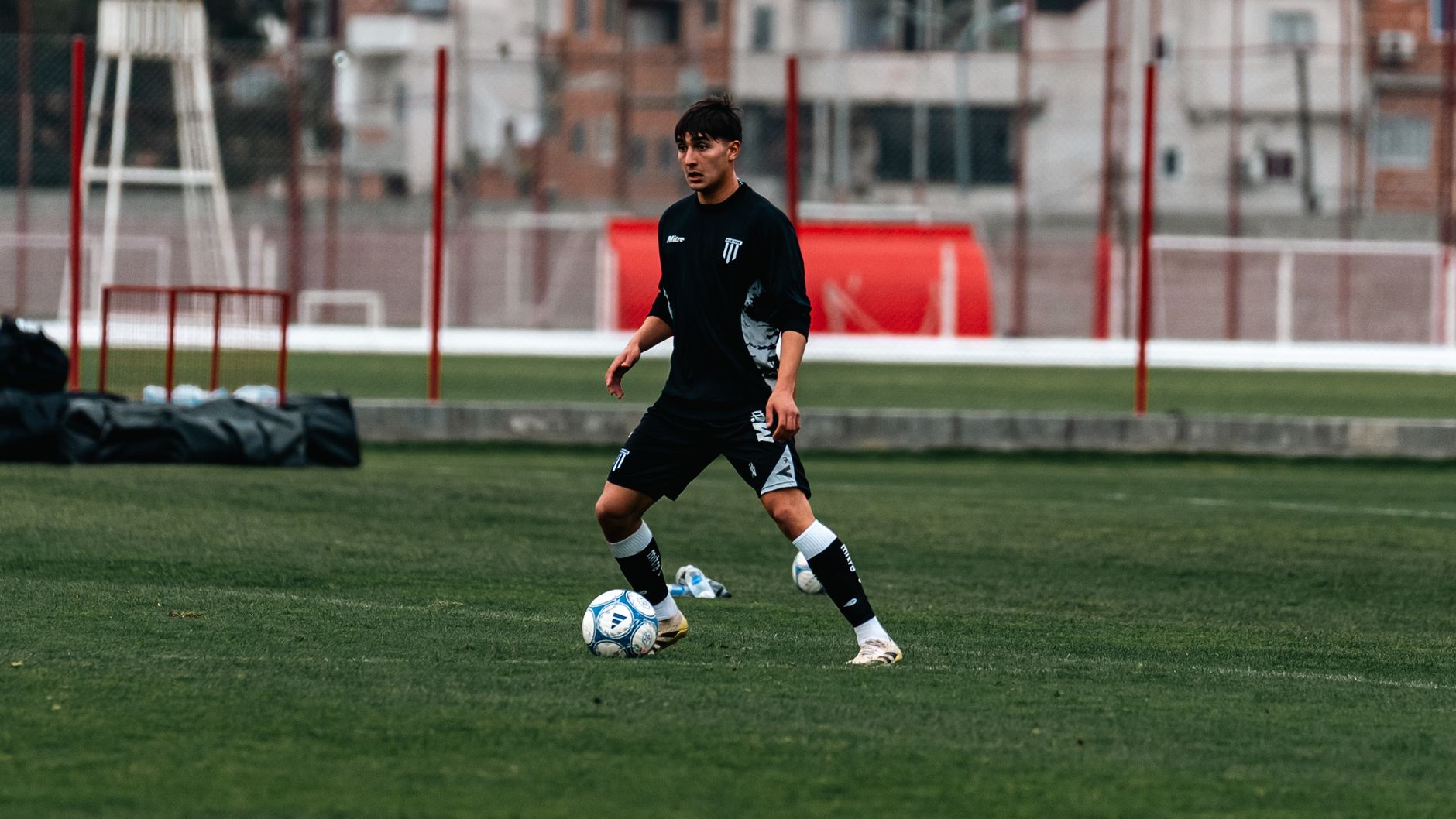 Teen soccer player in action during practice on a grassy field.