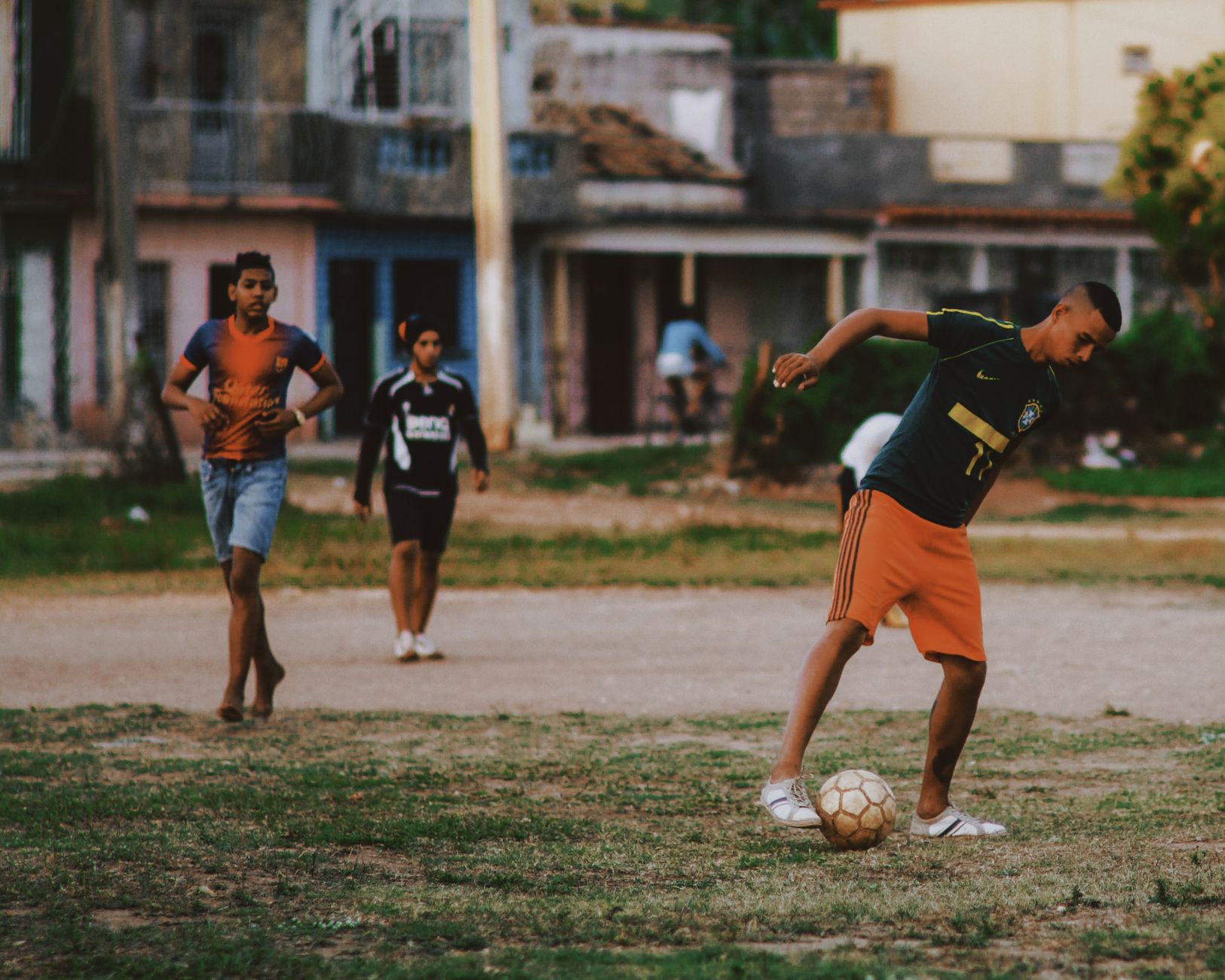 Teenagers playing soccer in an urban setting, capturing lively street sports.
