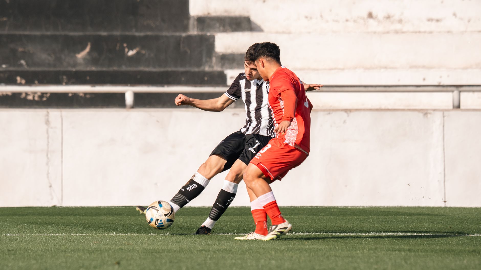 Two players competing for the ball in an exciting soccer match.