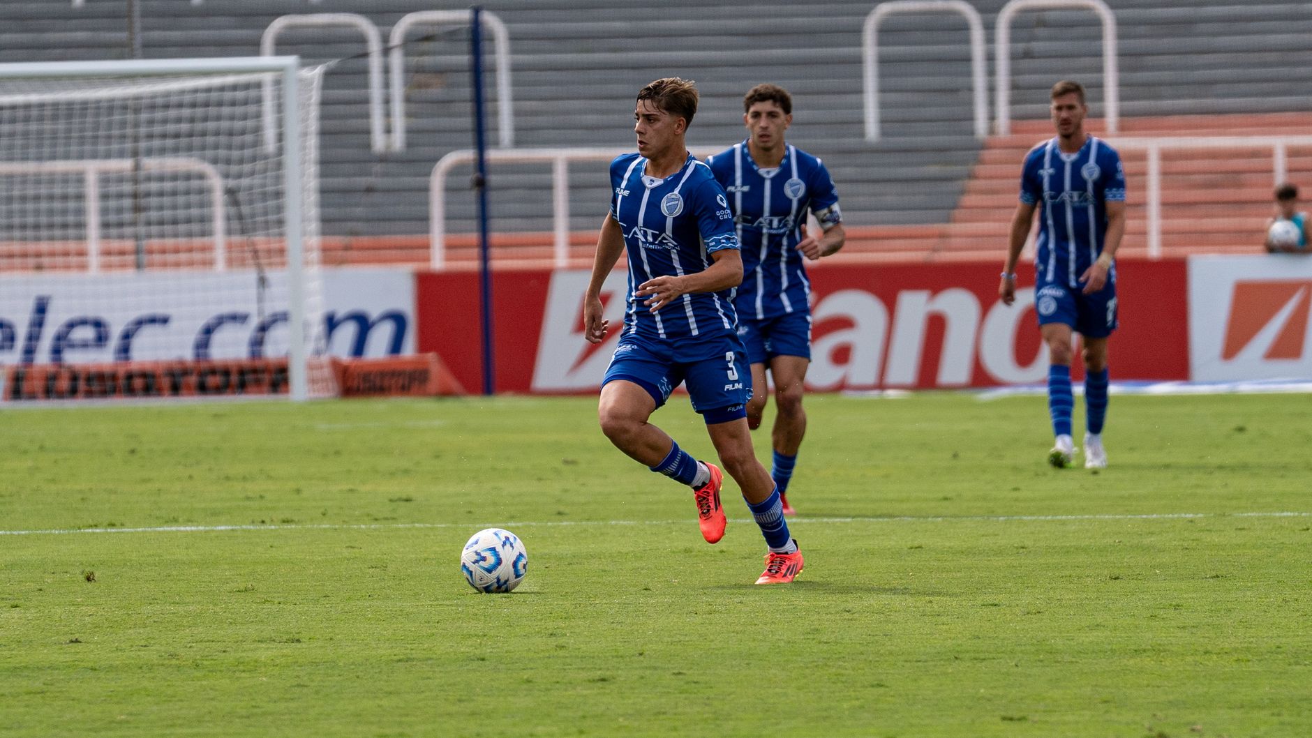 Exciting action shot of soccer players in blue jerseys during a match.