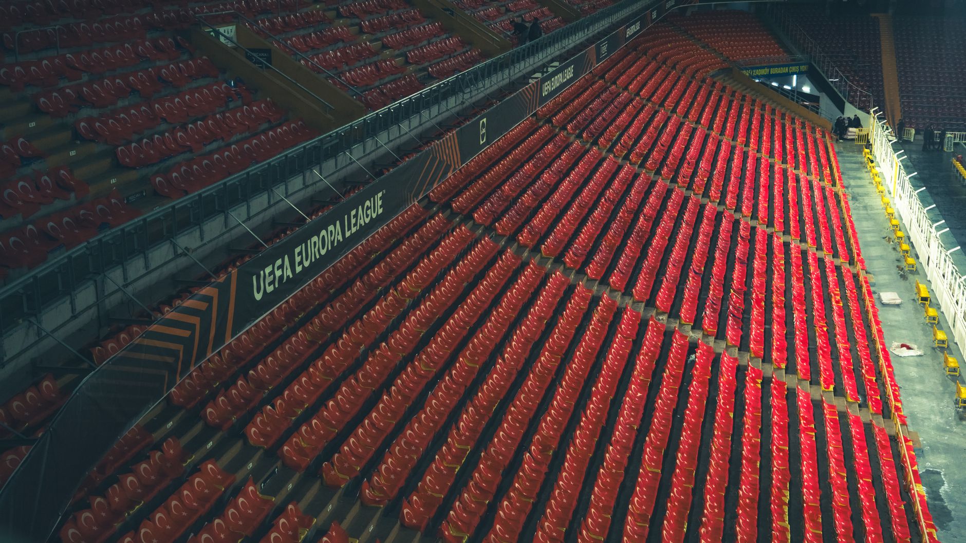 Rows of red seats in an empty stadium with UEFA Europa League signage.