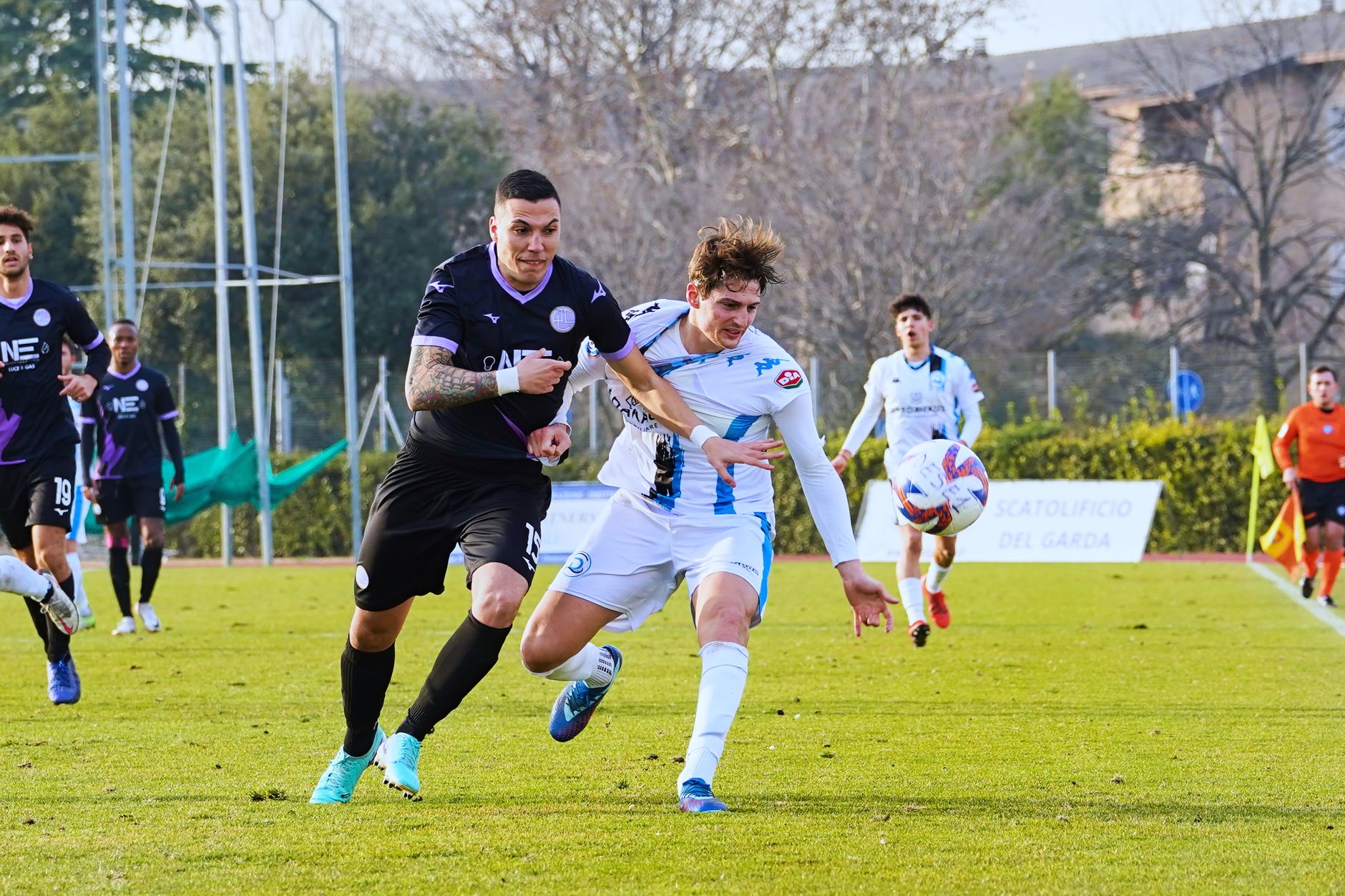 Two soccer players competing fiercely for the ball during an outdoor match.
