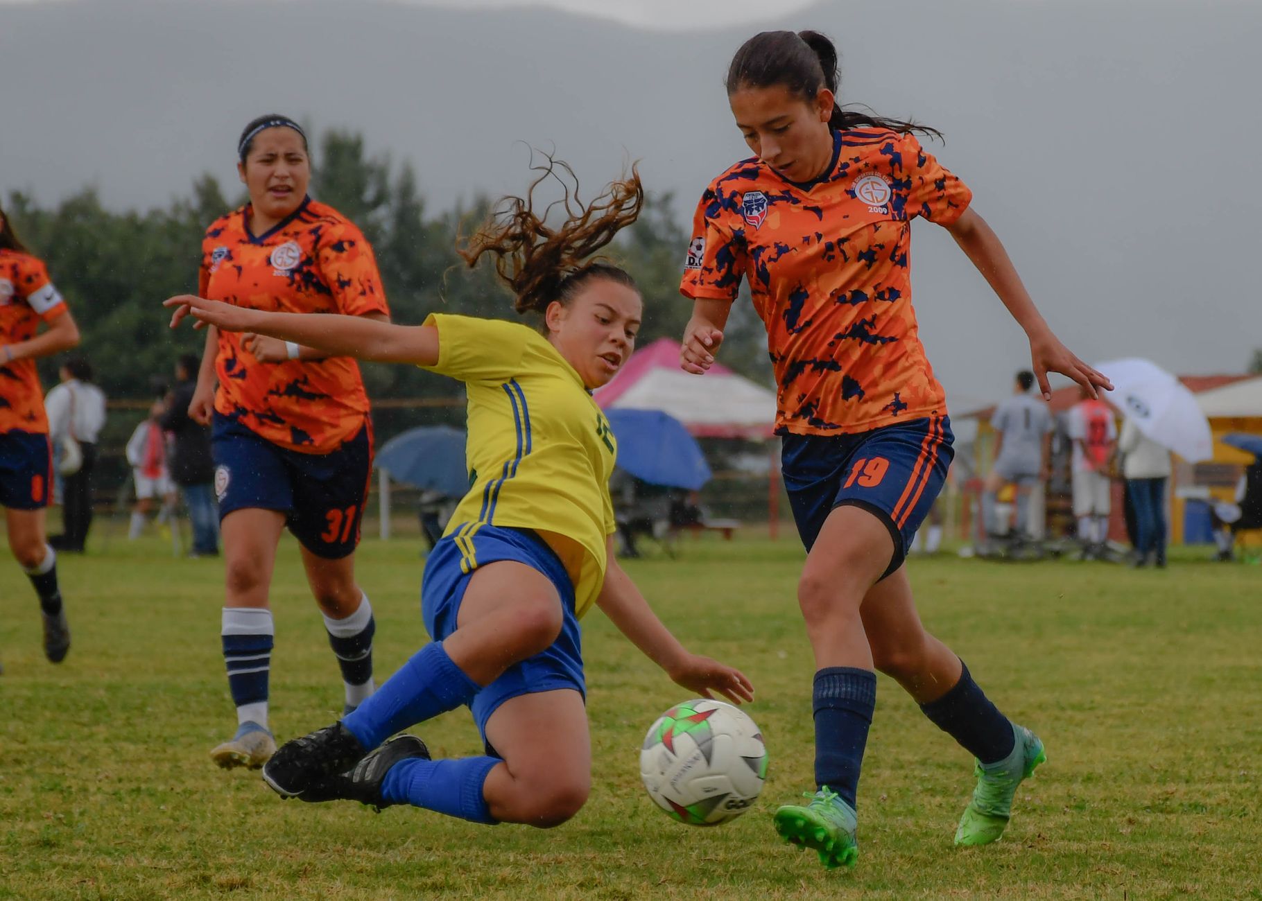 Dynamic action shot of a women's soccer game, showcasing players in vibrant uniforms competing on the field.