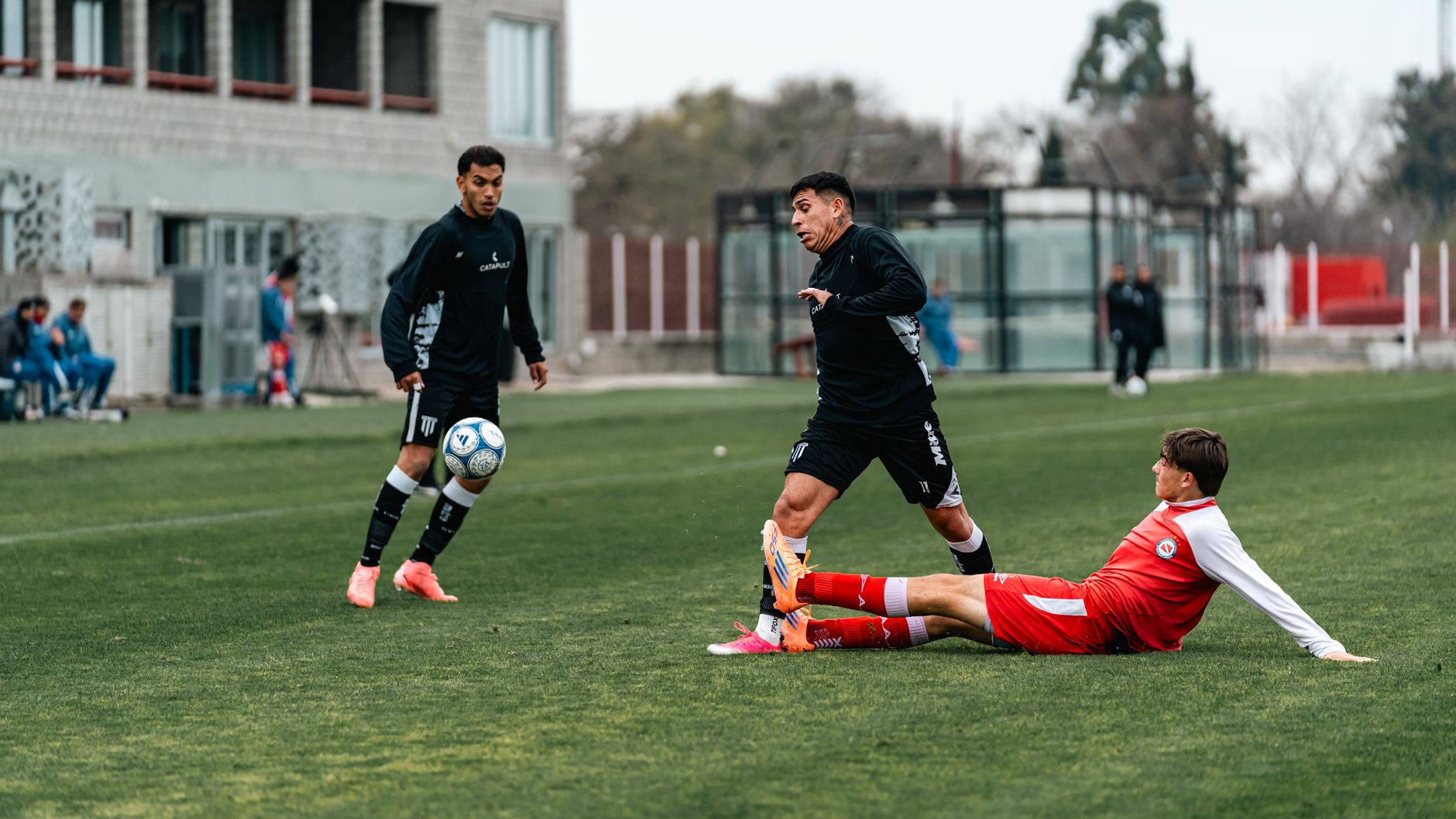 Players in action during an intense soccer match outdoors, showcasing teamwork and competition.