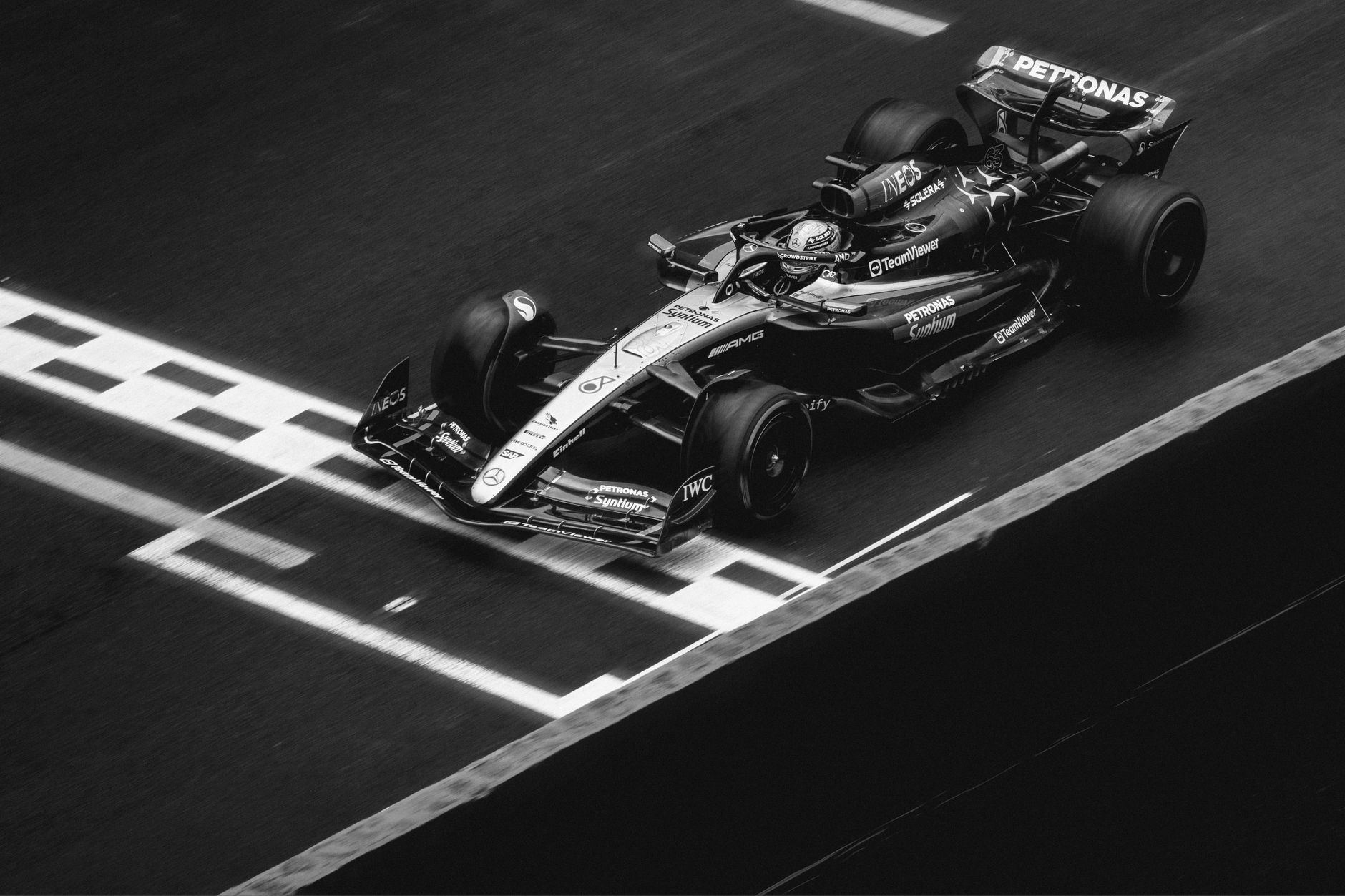 Black and white image of a Formula 1 car crossing the finish line on the track.