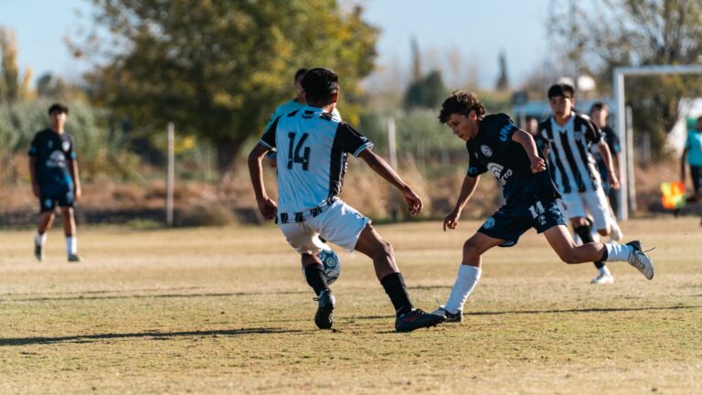 Dynamic youth soccer game capturing a player tackle in outdoor field on a sunny day.
